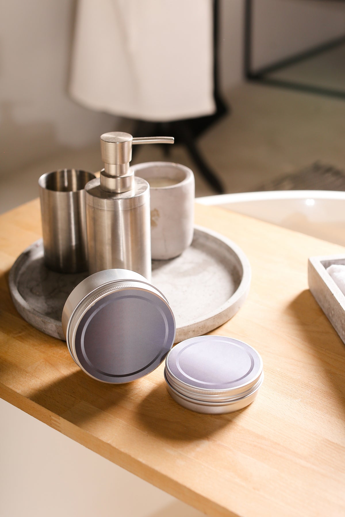 Bathroom counter with soap dispenser, containers, and a lamp in the background